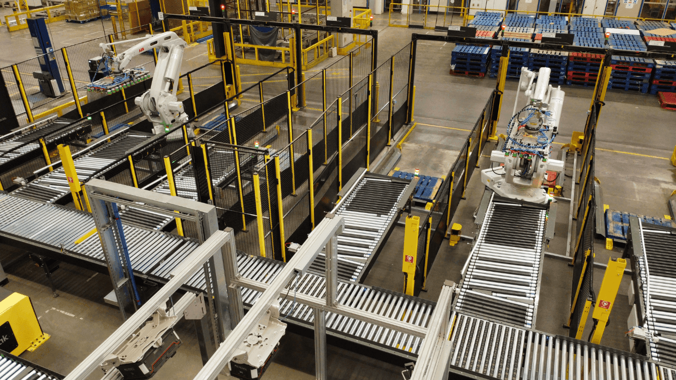 Warehouse conveyor system with robotic arms for palletising and automation