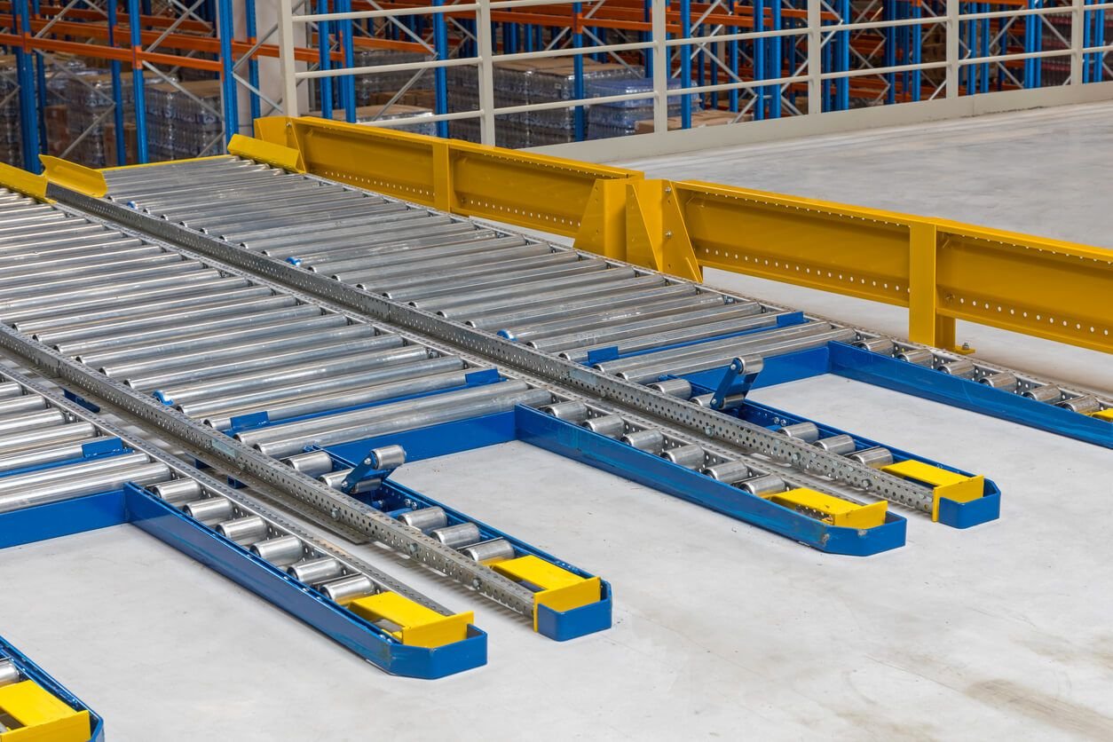 Gravity roller conveyor lanes installed in pallet racking to enable controlled product flow and lower handling costs.