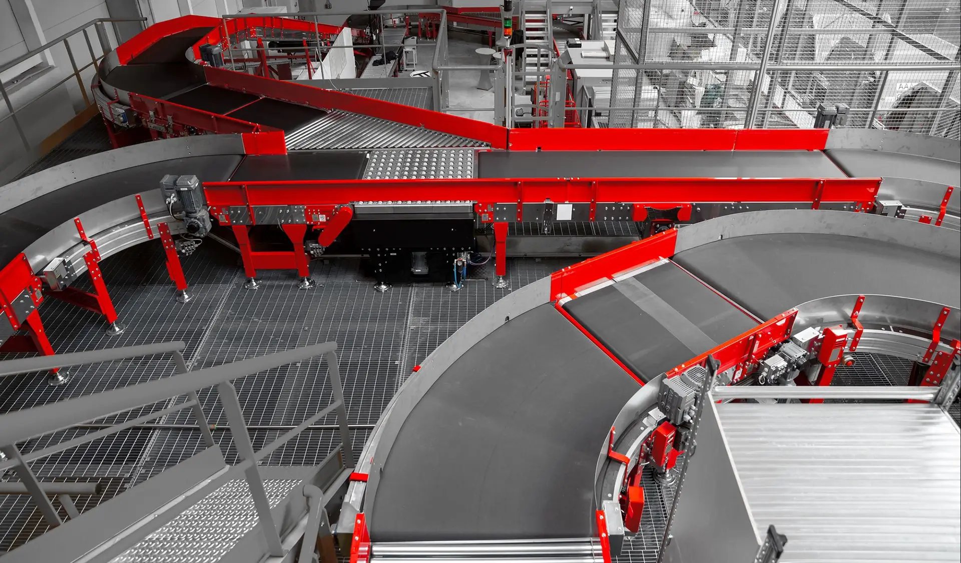 A large-scale automated conveyor system with a red belt, used for logistics and comprehensive material handling.