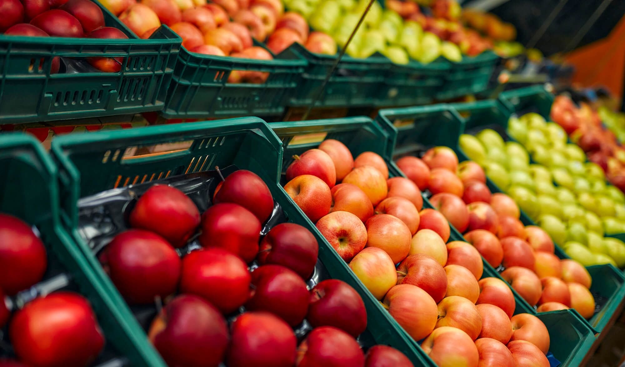 Crates of fresh apples, representing the grocery and food industry.